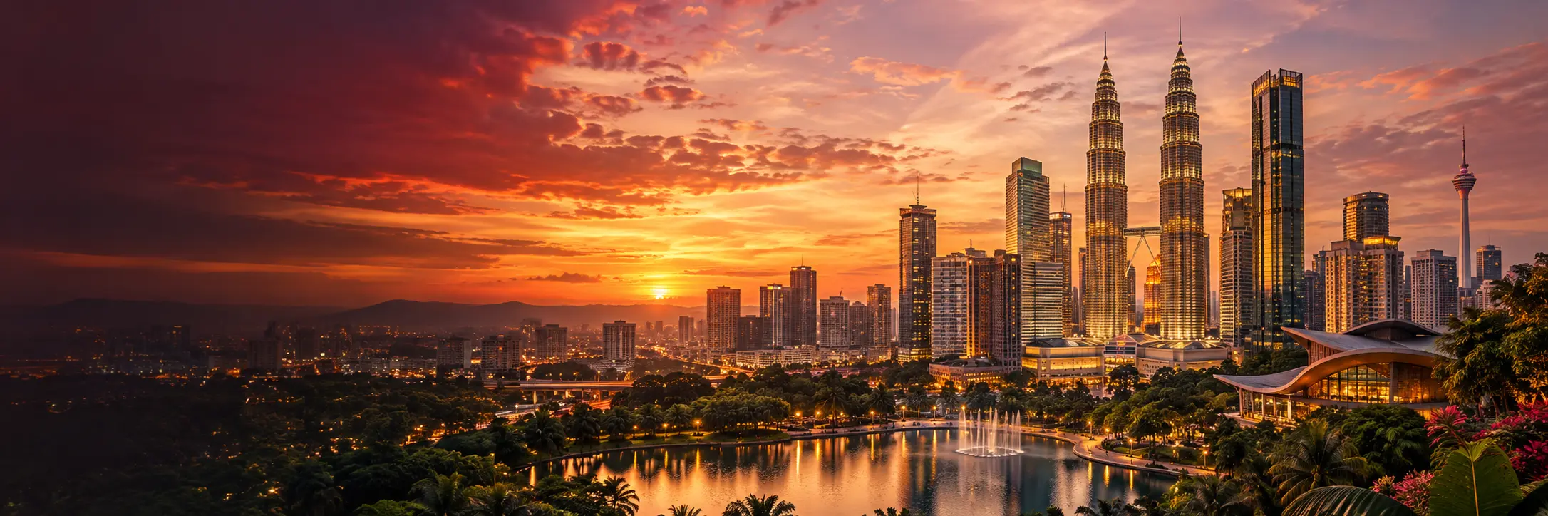 Kuala Lumpur skyline at dusk across the Klang basin, with the Petronas Twin Towers and KL Tower
